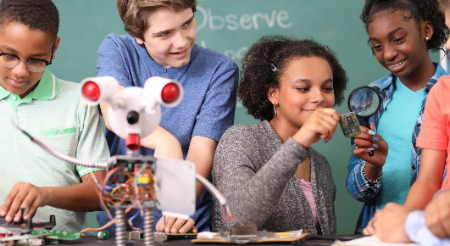 Four students playing with a robot 